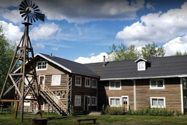 a large brick building with grass in front of a house