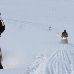 a man riding a snowboard down a snow covered slope