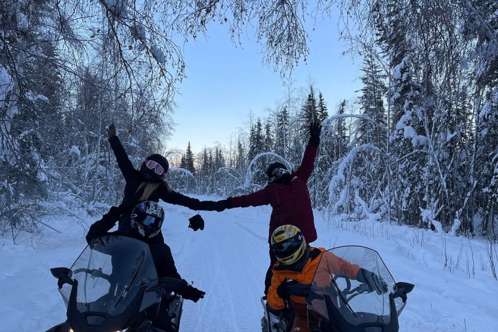 a man sitting on the side of a snow covered slope