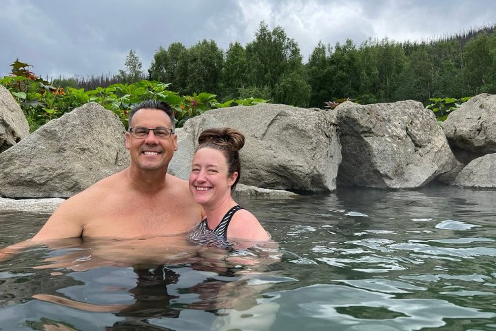 a man sitting on a rock next to water