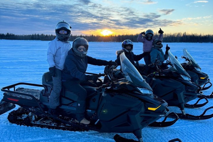 a group of people sitting on a motorcycle in a body of water