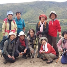 a group of people posing in front of a mountain