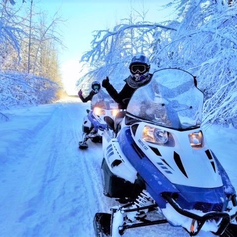 a man riding a motorcycle on the side of a snow covered slope