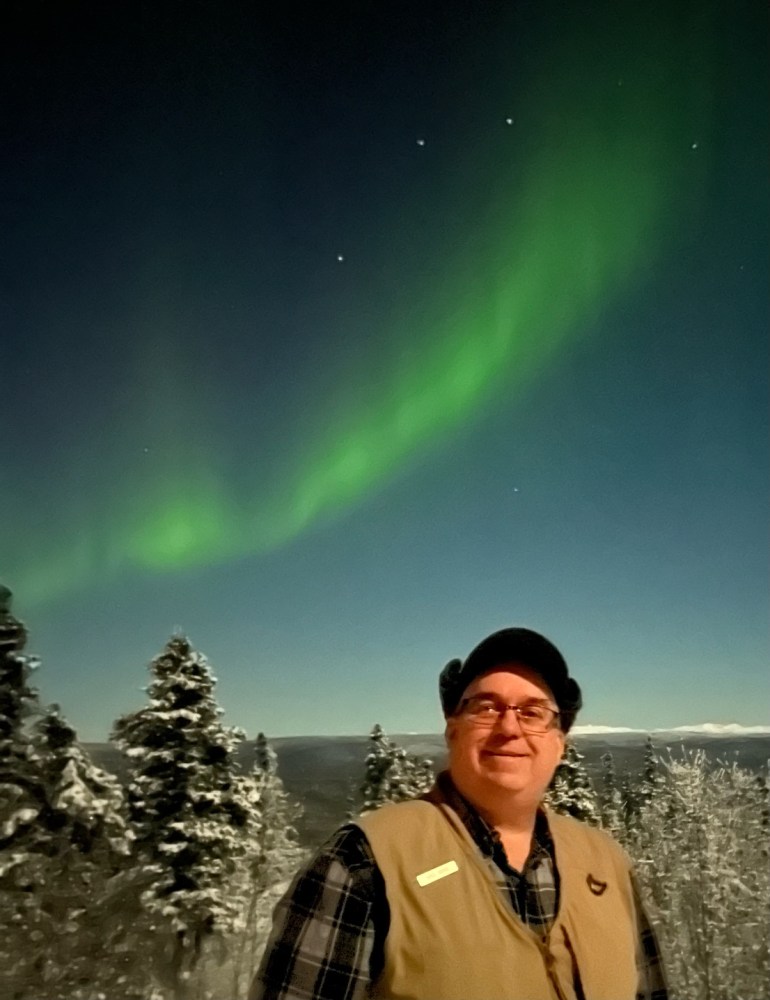 a man standing next to a body of water