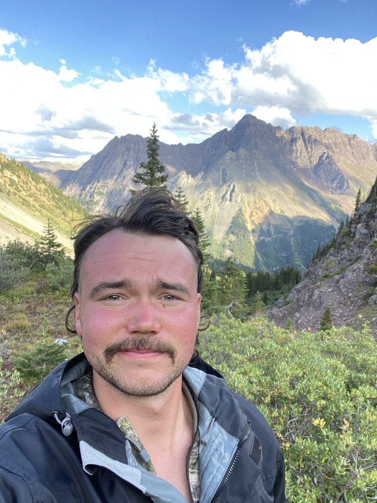 a man standing in front of a mountain